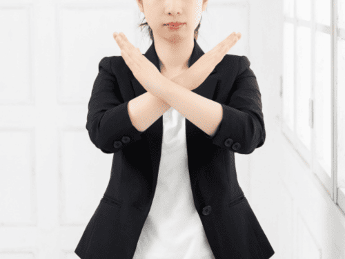手でバツを作る女性サラリーマン