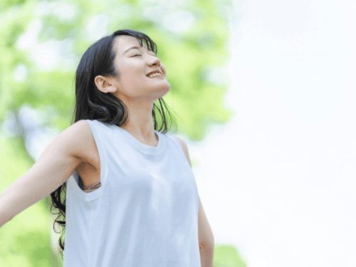 森林の中で深呼吸する女性