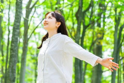 田舎の森で深呼吸する女性