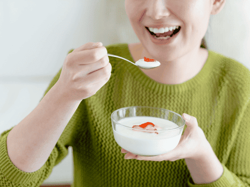 ヨーグルトを食べている女性