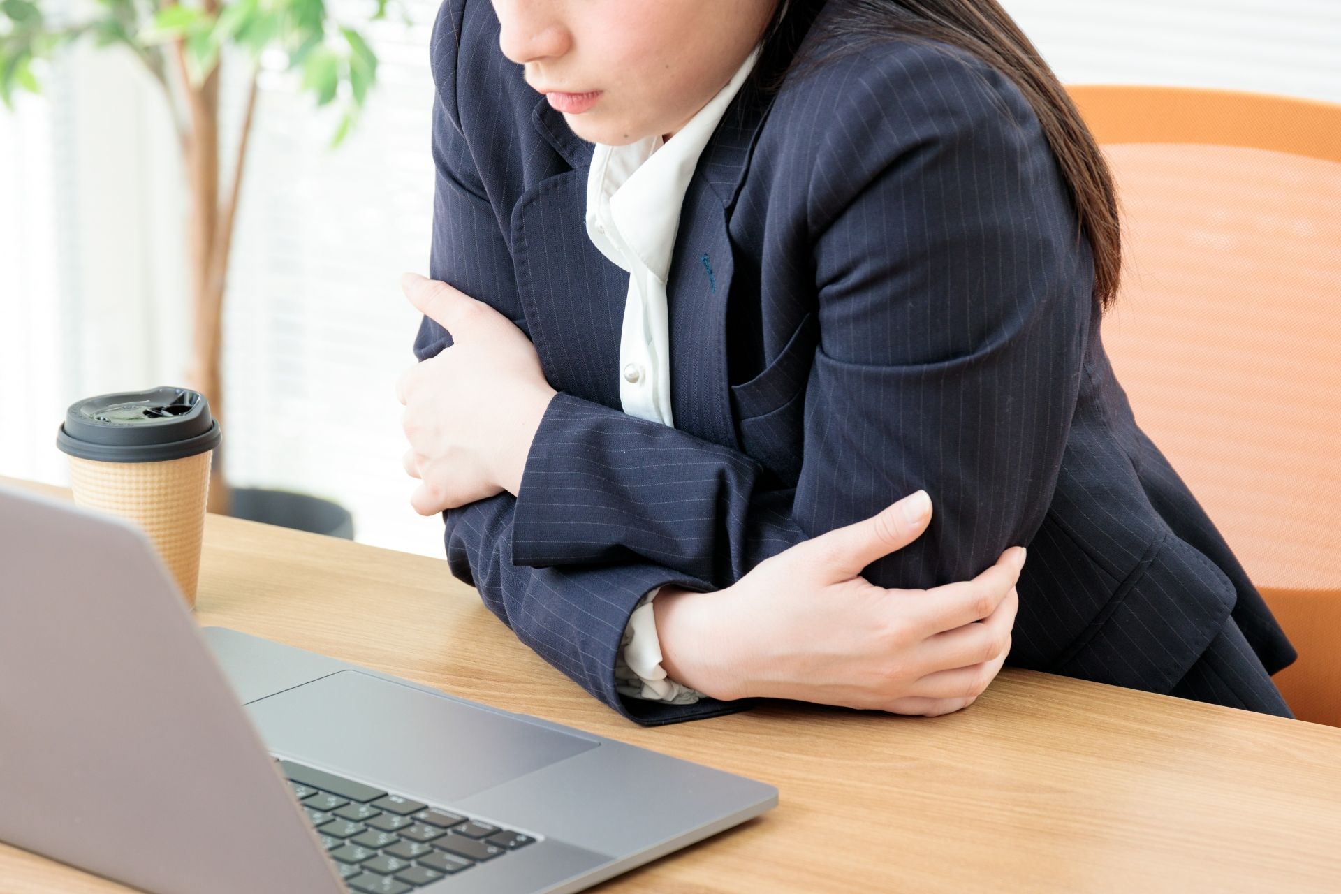 オフィスで寒さを感じている女性