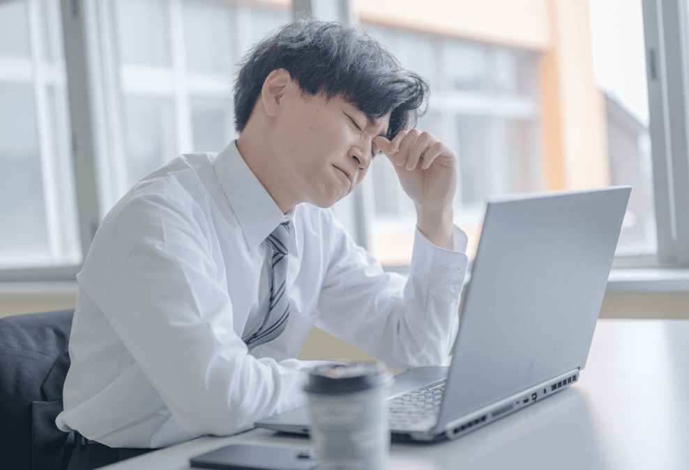 パソコンの前で悩む男性