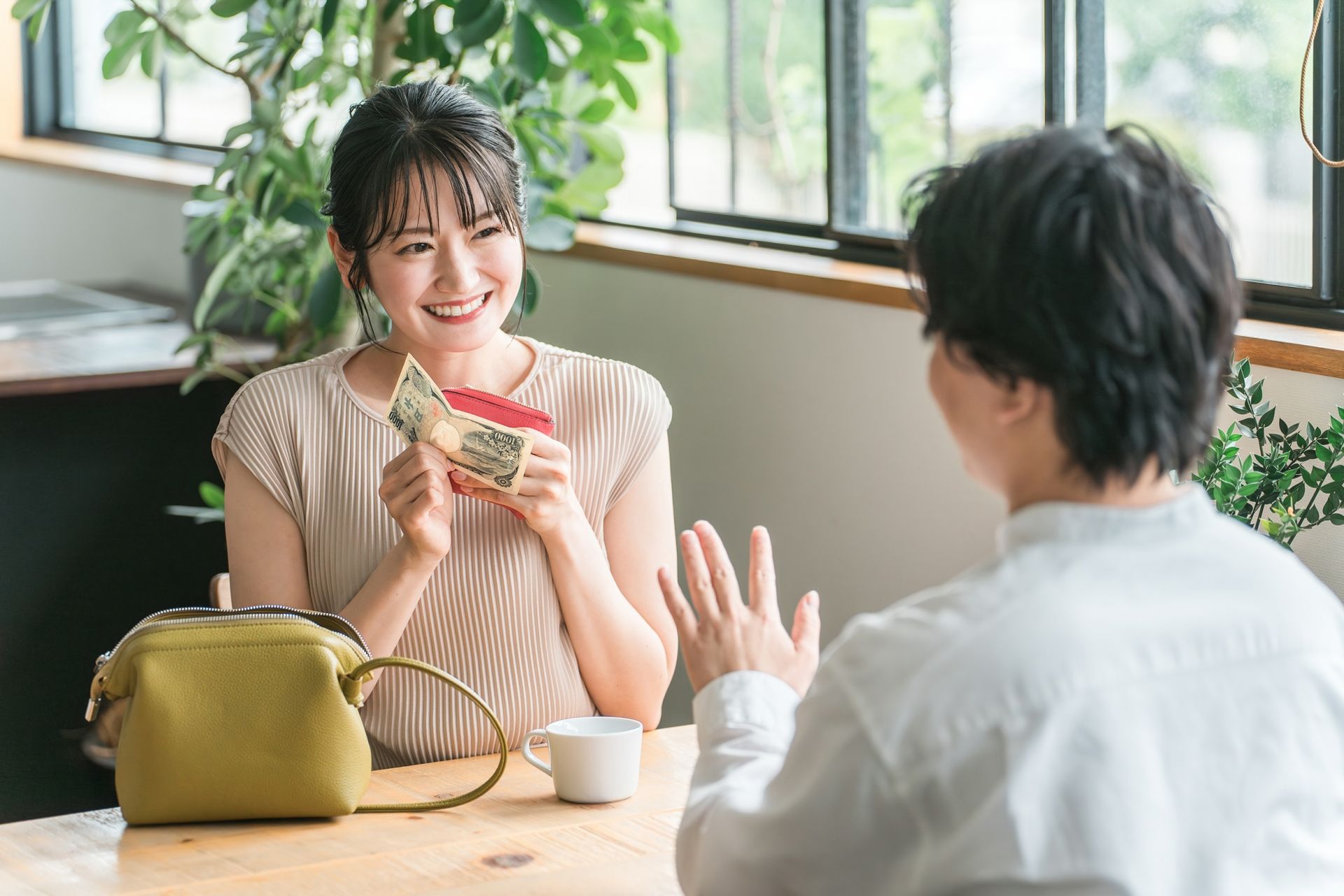 支払いをしようとする女性とそれを止める男性