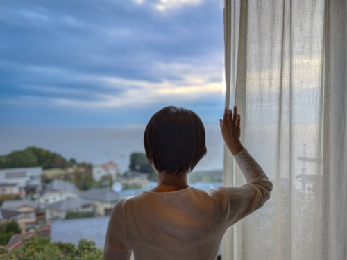 カーテンを開ける女性