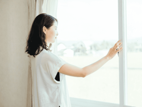 カーテンを開ける女性