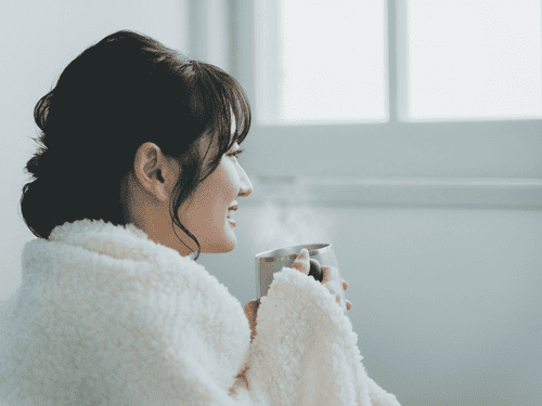 温かい飲み物でリラックスしている女性