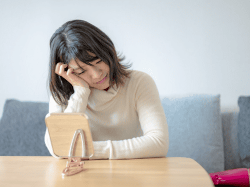 鏡の前で頭を抱える女性